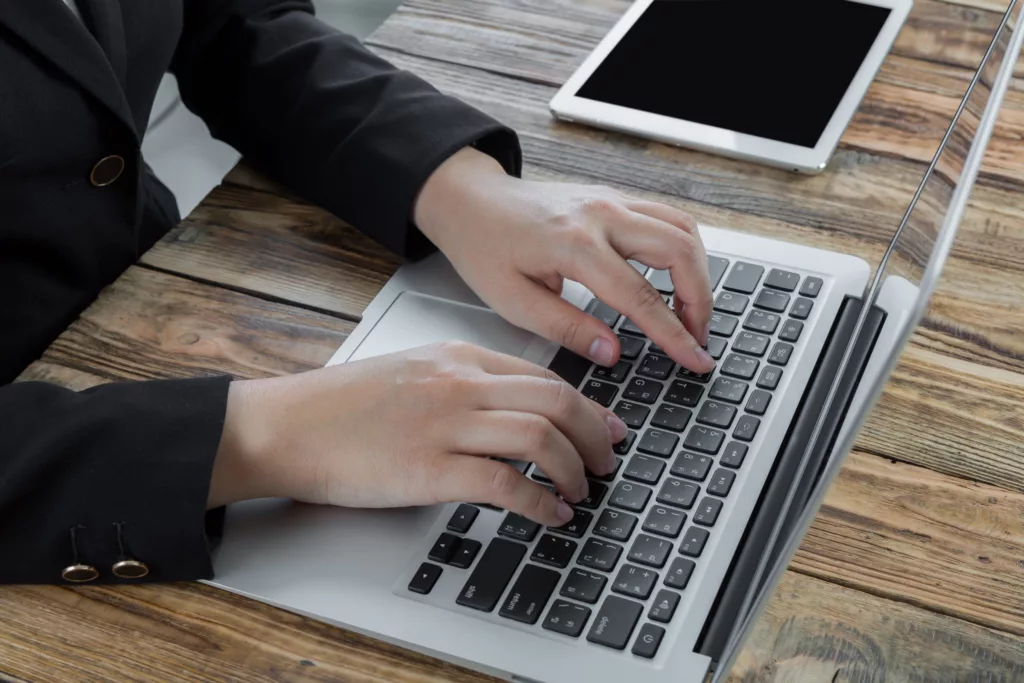 Closeup of business woman hand typing on laptop keyboard